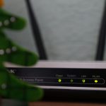 white and black modem router with four lights