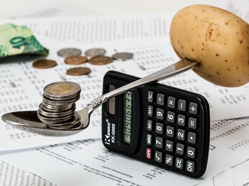 Ouders plannen het gezinsbudget aan de keukentafel met een telefoon en aantekeningen