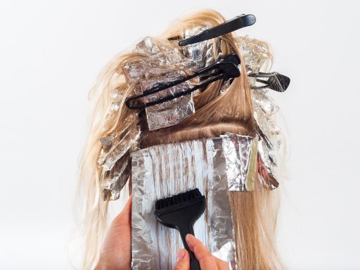 Vrouw in kappersstoel met warme herfsttinten in haar haar