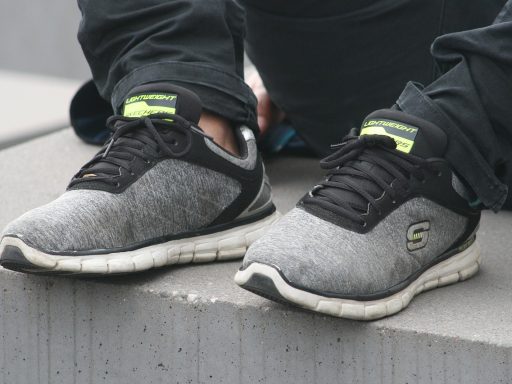 Een man in een lichtgrijze blazer met witte sneakers, een voorbeeld van stijlvol casual Nederlandse mannenstijl