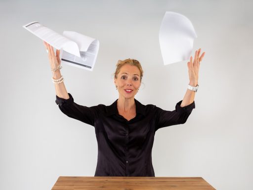 Vrouw schrijft aantekeningen in notitieboekje aan bureau terwijl ze haar dag plant