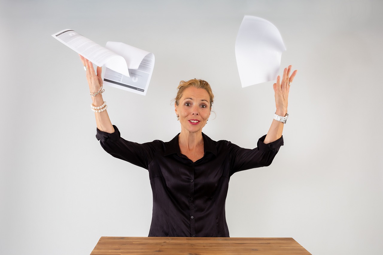 Vrouw schrijft aantekeningen in notitieboekje aan bureau terwijl ze haar dag plant