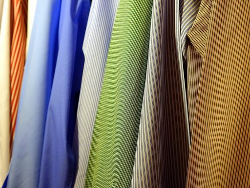 Een overzichtelijk kledingrek met neutrale, gecombineerde basisstukken voor een capsule-garderobe