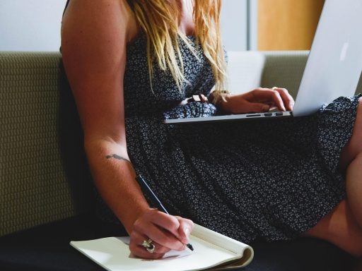 Vrouw die haar financiën plant met een notitieboek en smartphone op tafel